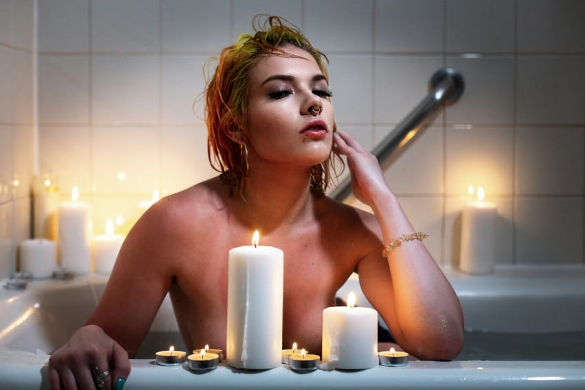 Frau in Badewanne mit Kerzen hat multiple Orgasmen