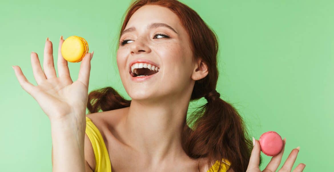 erotische fantasien, welcher sex macht wirklich glücklich? lachende frau kann sich nicht zwischen zwei macarons entscheiden