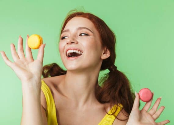 erotische fantasien, welcher sex macht wirklich glücklich? lachende frau kann sich nicht zwischen zwei macarons entscheiden