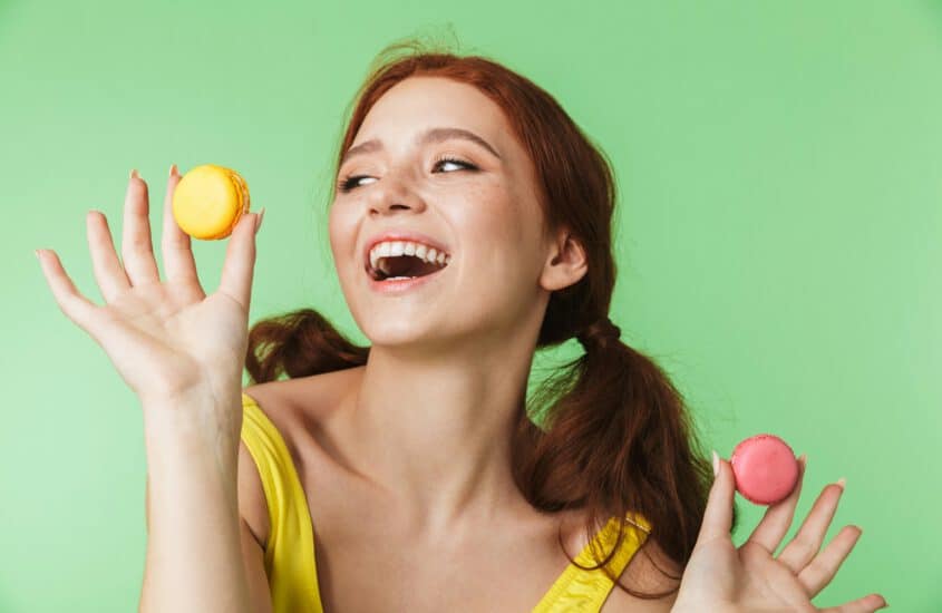 erotische fantasien, welcher sex macht wirklich glücklich? lachende frau kann sich nicht zwischen zwei macarons entscheiden